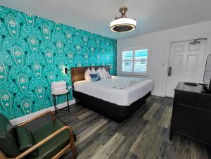 a bedroom with a bed and a green wall at Tahitian Beach Resort in St Pete Beach