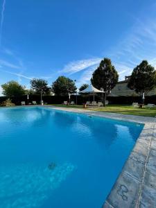 a large blue swimming pool in front of a house at Agriturismo La Colmata in Cesa