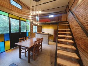 ein Esszimmer mit einem Holztisch und einer Ziegelwand in der Unterkunft Loft El Taller - Rústico, elegante, acogedor in Yerba Buena