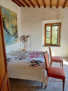 a bedroom with a bed and a window and a chair at Il Casolare del Pastore in Suvereto