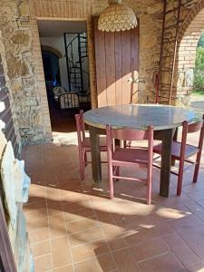 a wooden table and chairs on a patio at Il Casolare del Pastore in Suvereto