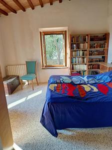 sypialnia z łóżkiem i półką na książki w obiekcie Il Casolare del Pastore w mieście Suvereto