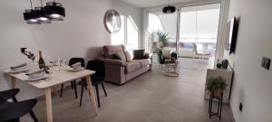 ein Wohnzimmer mit einem Tisch und einem Sofa in der Unterkunft Apartment Las Terrazas Costa Adeje Ocean View in Adeje