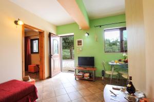 a room with a bed and a table with a television at Villa Casa Bianca Orange Apartment in Gaios
