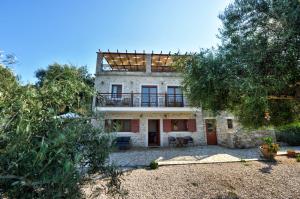 ein externer Blick auf ein Haus mit Bäumen in der Unterkunft Villa Casa Bianca Orange Apartment in Bogdanátika