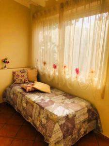 una camera con letto e finestra con fiori di Casetta del sole a Lampedusa