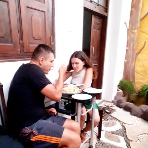 un hombre y una mujer sentados en una mesa comiendo comida en Dihini Villa, en Unawatuna