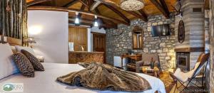 a bedroom with a bed and a stone wall at Μαγεμένο Βουνό in Karpenisi