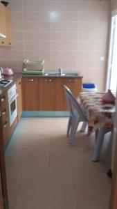 eine Küche mit Tisch und Spüle in der Unterkunft Yasmine appartement A7 in Nabeul