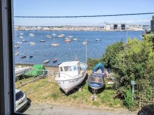 two boats are parked on the grass near the water at Helens View in Torpoint