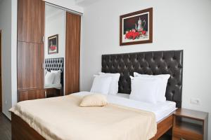 um quarto com uma cama grande e uma cabeceira preta em Motel Celebic em Podgorica