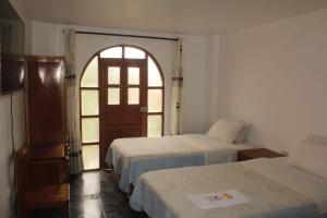 a room with two beds and an open door at MESONERO in Ayacucho