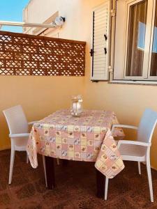 un tavolo con due sedie e una tovaglia sopra di Casetta del sole a Lampedusa
