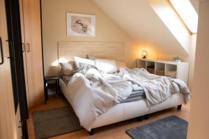 um quarto com uma grande cama branca num sótão em Studio 953 - Your Peace of Mind, AC & parking em Budapeste