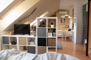 een woonkamer met een witte boekenplank en een tv bij Studio 953 - Your Peace of Mind, AC & parking in Boedapest