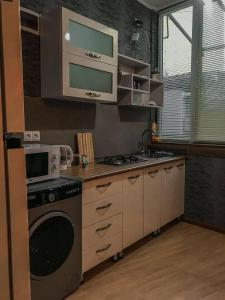 提比里斯的住宿－Sioni Apartment，厨房配有炉灶和微波炉。