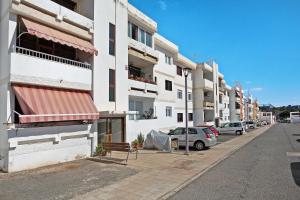 a building with a red awning and cars parked on a street at Casa Aliana in Puerto del Rosario