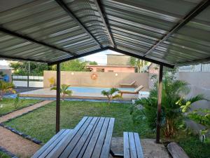 een patio met twee houten banken onder een luifel bij Villa Jehan Tourist Residence in Souillac