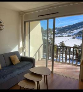 uma sala de estar com um sofá e uma porta de vidro deslizante em U061 - Grand studio rénové - Vue montagne em Gréolières
