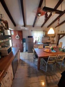 kuchnia z drewnianym stołem oraz duża kuchnia ze stołem i krzesłami w obiekcie Holiday Home Mali Anđeo w mieście Suza