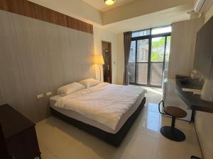 內埔鄉的住宿－愛瑪仕民宿，一间卧室设有一张大床和一个窗户。