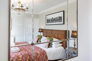 1 dormitorio con 1 cama con espejo en Cannich Cottage at Parbroath Farm, en Cupar
