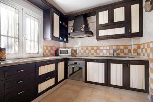 una cocina con armarios de color marrón oscuro y fregadero en Villa Viruta en El Bosque