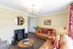 a living room with a couch and a fireplace at Cannich Cottage at Parbroath Farm in Cupar