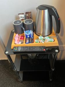 錫豪西斯的住宿－Links Lets Room Only，一张桌子,上面有咖啡壶和遥控器