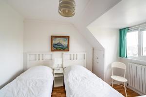 2 camas en un dormitorio con escritorio y silla en Joli appartement moderne, pour 4, a Benodet, en Bénodet