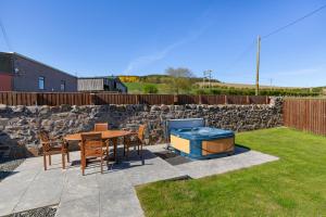 a patio with a table and chairs and a grill at Cannich Cottage at Parbroath Farm in Cupar