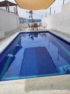 a swimming pool with a table and chairs in it at Casa Horizonte Azul Acapulco in Acapulco
