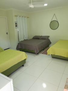 een slaapkamer met 2 bedden en een spiegel aan de muur bij Hotel Pousada universitária Bauru, CPO ,centrinho, funcraf ,USP, FACOP ,Agudos ,parque Vitória Régia , UNESP , maternidade Santa Izabel in Bauru