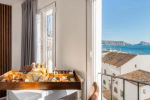 a room with a table and a window with a view at Porta Nova Suites Altea - Adults Only in Altea