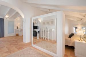 a room with a bed and a living room with a mirror at Porta Nova Suites Altea - Adults Only in Altea