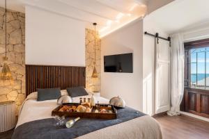 a bedroom with a bed with a tray of food on it at Porta Nova Suites Altea - Adults Only in Altea