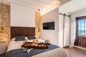 阿爾啼的住宿－Porta Nova Suites Altea - Adults Only，一间卧室配有一张床,上面放着一个食物托盘