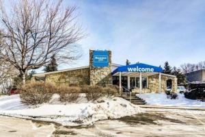 un magasin de watsonine avec un auvent bleu dans la neige dans l'établissement Rodeway Inn, à Washington