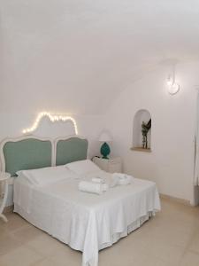 una camera da letto con un letto bianco con due asciugamani di Palazzo De Mori a Otranto