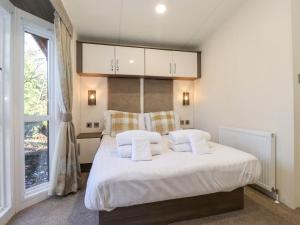a bedroom with a bed with white sheets and a window at Toucana in Morpeth