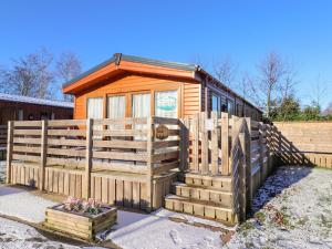a tiny house with a wooden fence and stairs at Toucana in Morpeth