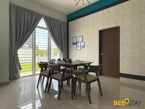 a dining room with a table and chairs and a window at Desaru Arcadia Villa 11-12pax Wifi Netflix BBQ SteamBoat Pool Table Beach Water Park in Kangkar Chemaran