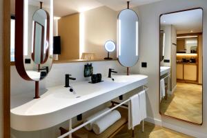 a bathroom with two sinks and two mirrors at TRS Ibiza Hotel - Adults Only in San Antonio