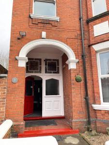 an entrance to a brick building with a white door at ISUITES in Newcastle under Lyme