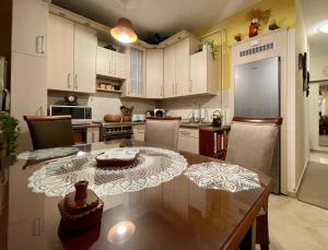 a kitchen with a dining table and a kitchen with white cabinets at Lola Lakásapartman Nagykanizsa in Nagykanizsa