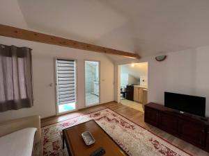a living room with a couch and a tv at Old Town Apartments in Novi Pazar