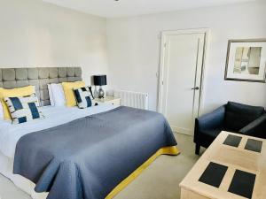 a bedroom with a large bed and a chair at The Thorpe Guesthouse in Huntingdon