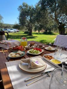 a wooden table with plates of food on it at Byelka Bungalov Ayvalık in Ayvalık +35 photos
