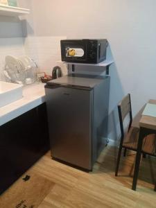 a microwave sitting on top of a refrigerator in a kitchen at Point Gate Inn in Bacolod
