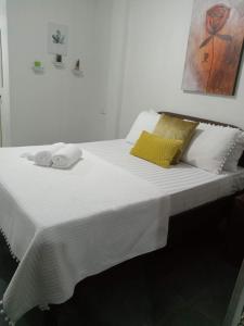 Una gran cama blanca con toallas encima. en Point Gate Inn, en Bacolod